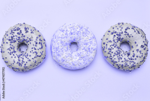 Delicious donuts in trendy violet color. Lilac color donuts dessert with copy space.