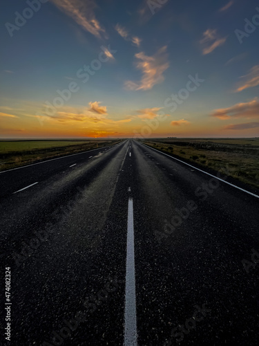 Beautiful look of an infinite road, highway going to a sunset in the Iceland highlands © Gian