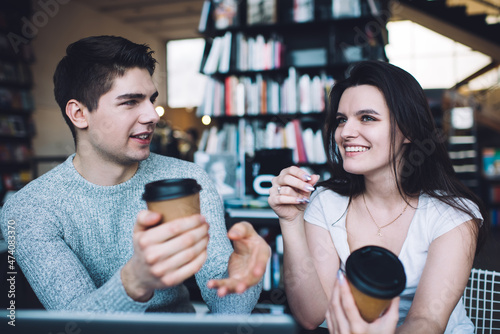 Young couple with cups of takeaway coffee in bookstore