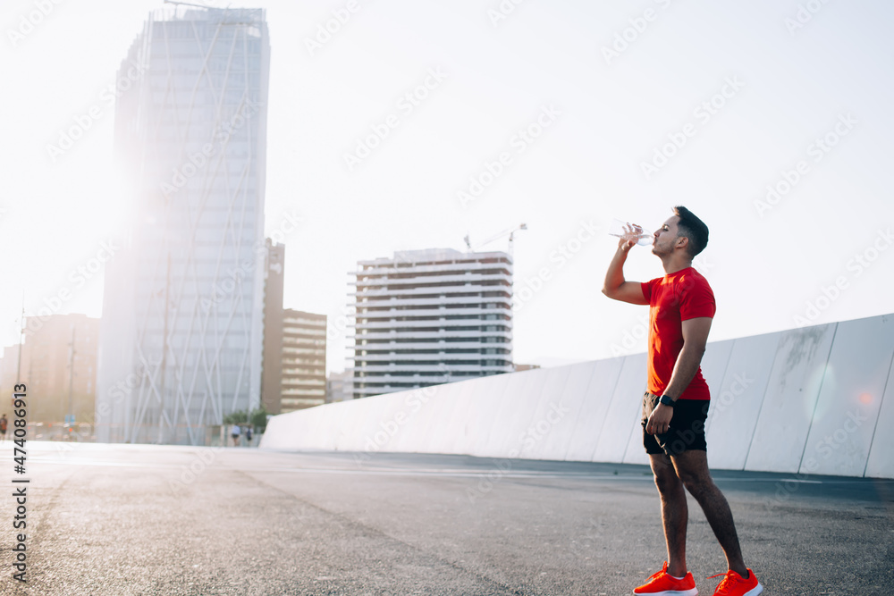 Young athletic man drinking water from bottle Young athletic man drinking water from bottle