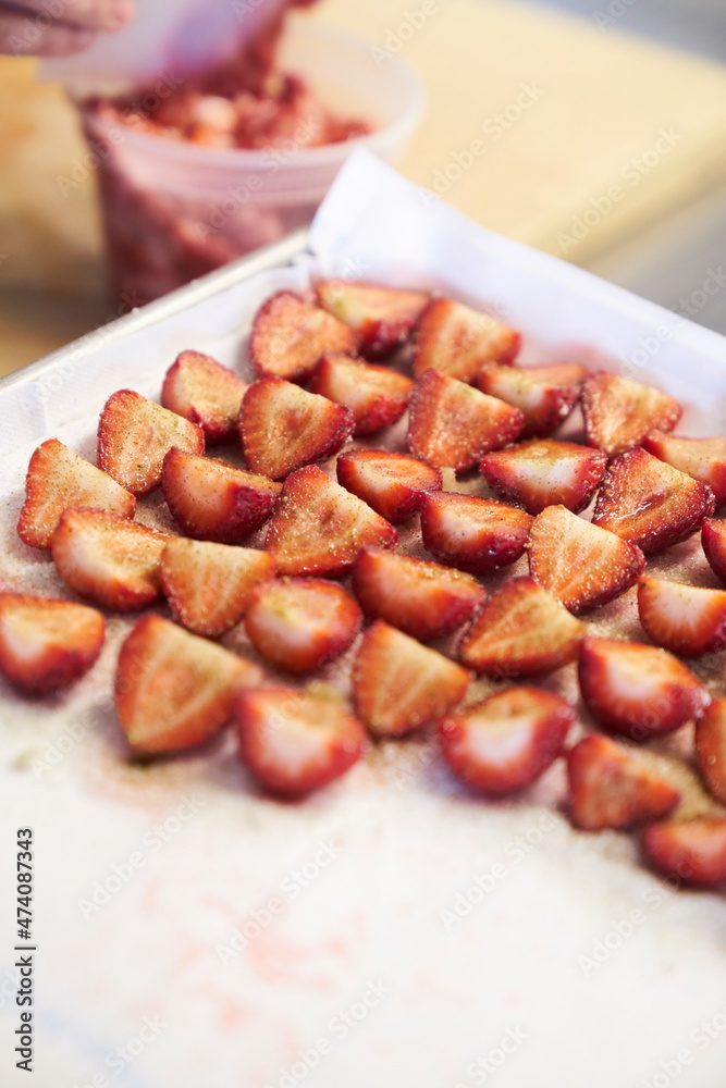 Maserated strawberry slices being prepped in a kitchen for dessert Maserated strawberry slices being prepped in a kitchen for dessert