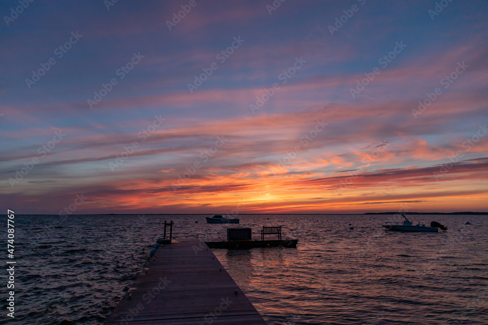 Breathtaking sunset sky over the ocean and dock.