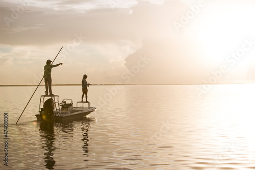 A man and woman fly fishing on a flats boat in the Florida Keys