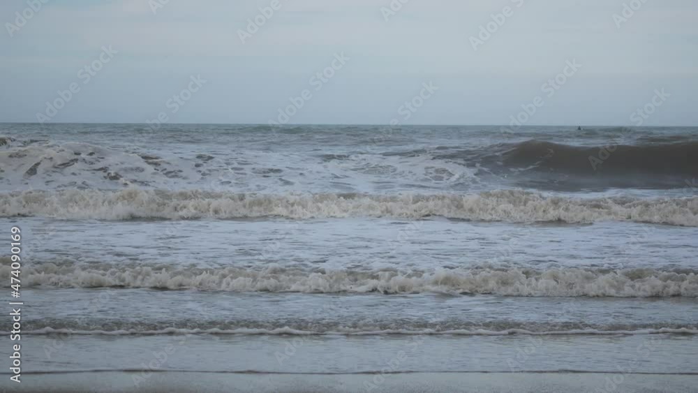 Waves of the Sea Reaching the Shore with Lots of Foam in a Cloudy and Cold Sky Waves of the Sea Reaching the Shore with Lots of Foam in a Cloudy and Cold Sky