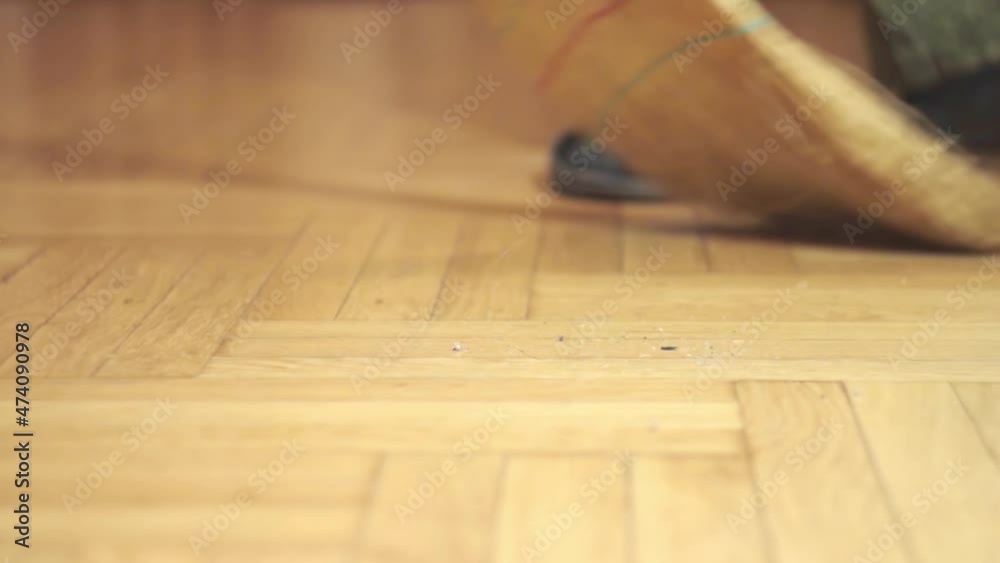sweeping debris from the parquet floor, blurred background sweeping debris from the parquet floor, blurred background