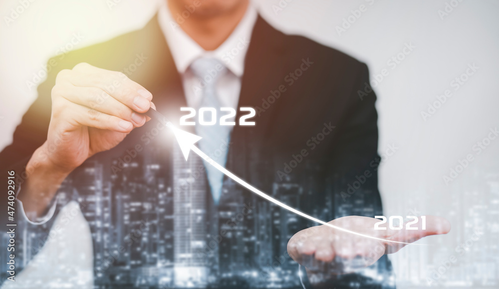 Double exposure of business growth data chart arrow with diagram 2022 budget, Businessman pointing arrow graph corporate future growth year 2021 to 2022, Development to success and motivation.