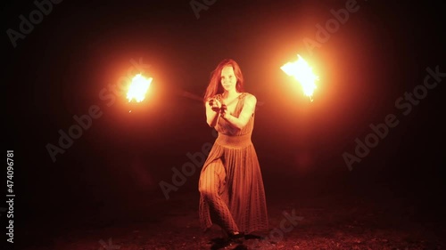 Woman with fireballs doing the show outdoors in the mountains photo