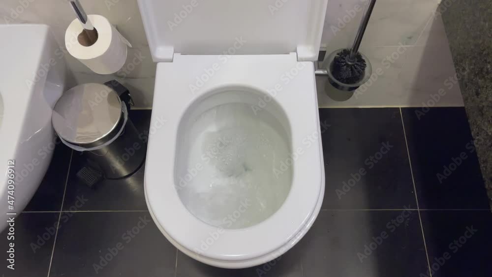 White toilet bowl top view. Flushing the toilet