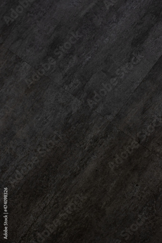 vertical image of the texture of a dark gray and black tile