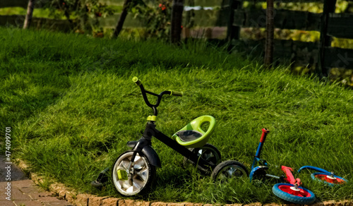 Dziecięce rowerki porzucone na trawniku . Children's bikes abandoned on the lawn.
