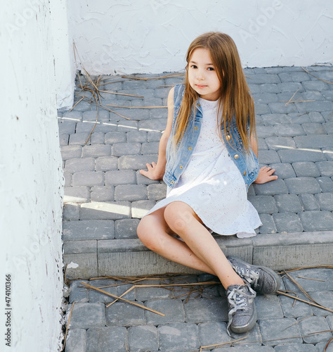 Beautiful girl with long hair in a white sundress in a light Balinese courtyard Greece Santorini vacation