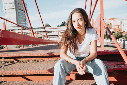 Cool hipster african young girl with curly hair, street hip hop style, looking serious defiant to camera, dynamics and expression. Copy space, social network concept. White tshirt denim jeans