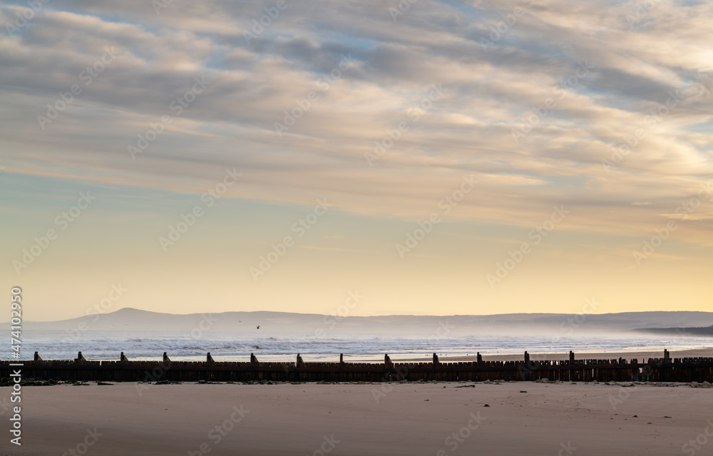 LOSSIEMOUTH, MORAY, SCOTLAND - 9 DECEMBER 2021: This is a scene at the east beach area of the harbour with waves just after sunrise at Lossiemouth, Moray, Scotland on 9 December 2021.