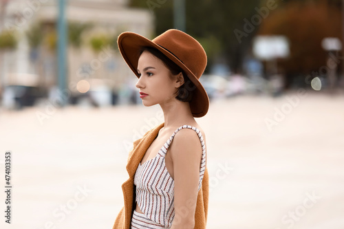 Murais de parede Young fashionable woman in felt hat on city street