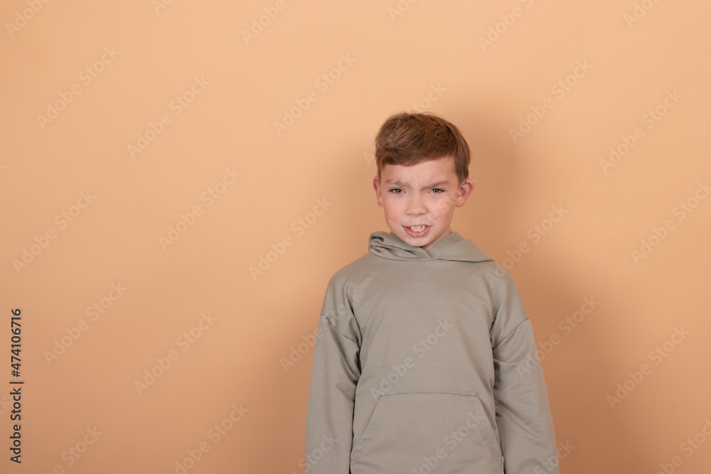 emotional portrait of a young boy teenager. charming school boy. beautiful kid. on light brown background. emotional portrait of a young boy teenager. charming school boy. beautiful kid. on light brown background.