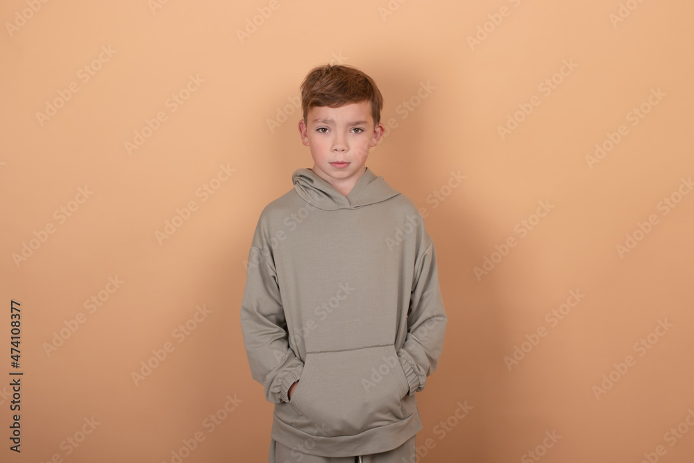 emotional portrait of a young boy teenager. charming school boy. beautiful kid. on light brown background. emotional portrait of a young boy teenager. charming school boy. beautiful kid. on light brown background.