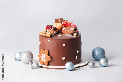 Stand with tasty Christmas chocolate cake and balls on light background