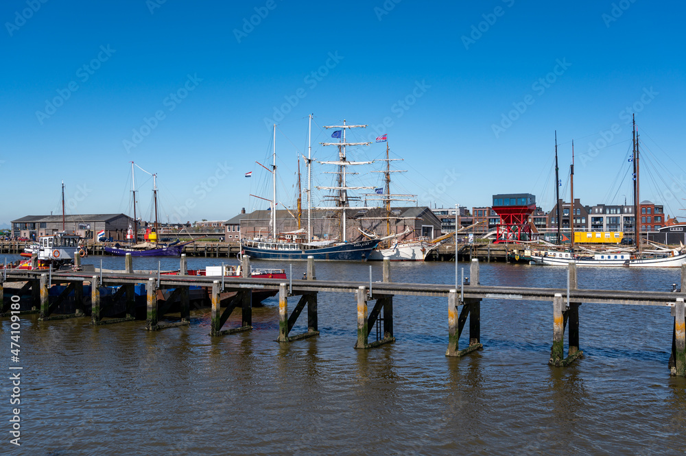 Fototapeta premium Walking on beach of Harlingen fisherman town on Wadden sea, Friesland, Netherlands at low tide