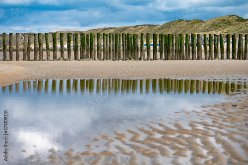 View on wooden poles at white sandy North sea beach near Zoutelande, Zeeland, Netherlands