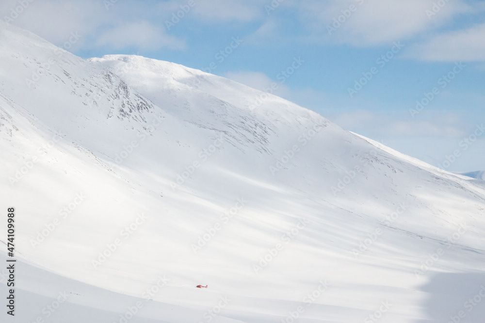 A helicopter that has just brought a couple of alpine skiers to Tjaktja pass, Kungsleden trail, Sweden, winter season, April