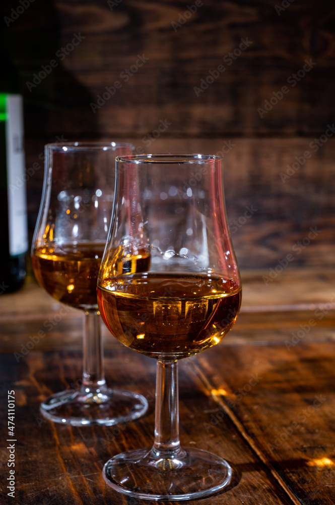 Glasses of strong scotch single malt whisky served on dark wooden table in old pub Glasses of strong scotch single malt whisky served on dark wooden table in old pub