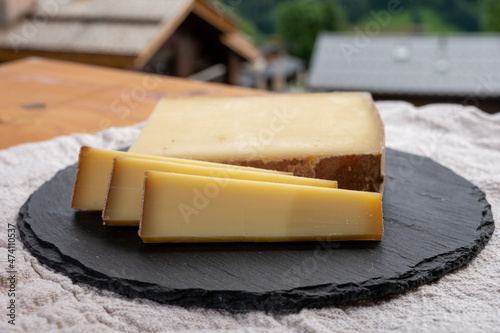 Cheese collection, French cow cheese comte, beaufort, abondance and french mountains village in Haute-Savoie on background