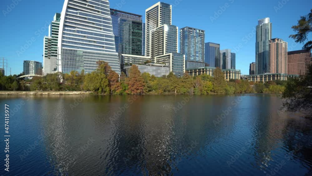 Static shot of tranquil Colorado River in Austin and giant high-rise buildings in background - Beautiful sunny day and blue sky in Texas,America Static shot of tranquil Colorado River in Austin and giant high-rise buildings in background - Beautiful sunny day and blue sky in Texas,America