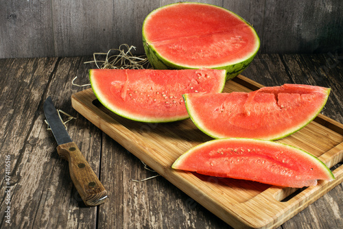 Fresh juicy tasty watermelon and watermelon slices on dark background