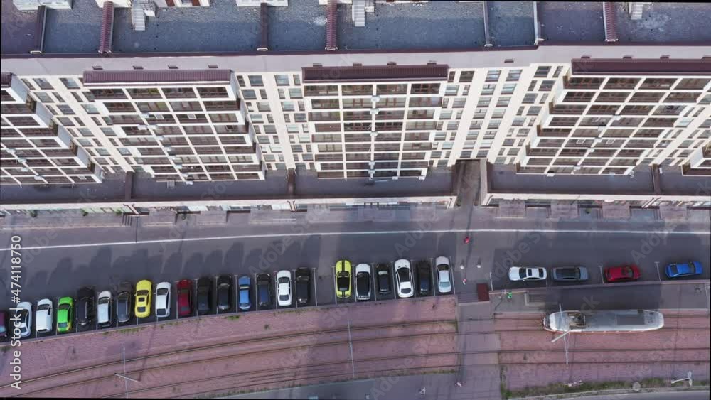 Drone top view Panoramic shot of Car Parking with cars near Modern Apartment Building at summer Morning. Modern cozy housing for investment and renting. Urban geometry of Luxury Apartment Building.