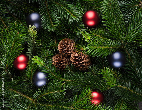 Evergreen fir branches with pine cones and christmas balls. Christmas background. Shot from above.