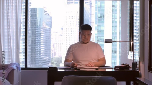 asian business man while answer telephone while working from hone