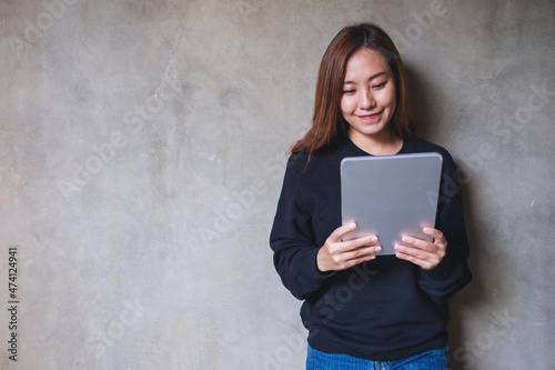 A beautiful young asian woman holding and using digital tablet © Farknot Architect