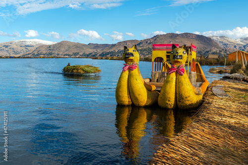 Totora reed boats by the Uros indigenous floating islands with reed transport, Titicaca Lake, Peru. photo