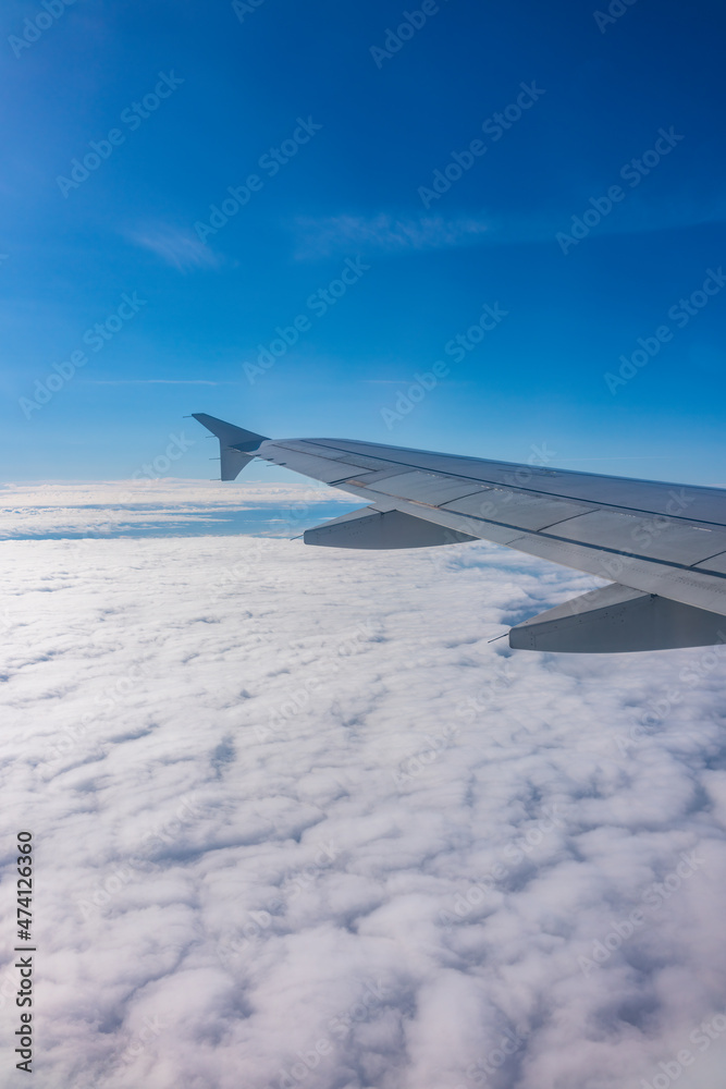View from the airplane window at a beautiful cloudy sky and the airplane wing View from the airplane window at a beautiful cloudy sky and the airplane wing