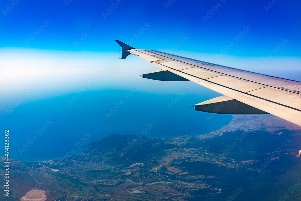 View from the airplane window at a beautiful blue clear sky and the airplane wing