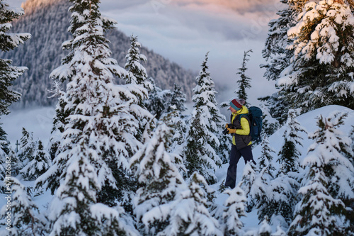 Woman hiker showshoer walking among snowy trees on Cypress Mountain Ski Resort. Vancouver. British Columbia. Canada