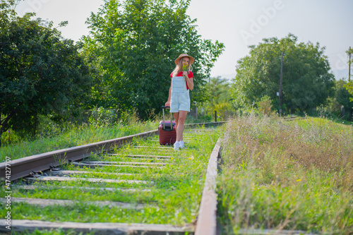 one traveler with flowers and a suitcase on the railway