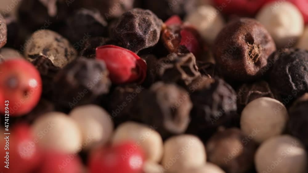 Mixed peppercorns falling in rotation, heap of spice, mix of different peppers closeup, slow motion Mixed peppercorns falling in rotation, heap of spice, mix of different peppers closeup, slow motion