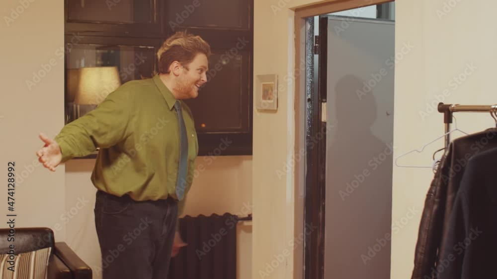 Modern ethnically diverse couple greeting friends invited for festive dinner entering their home and giving gifts to them Modern ethnically diverse couple greeting friends invited for festive dinner entering their home and giving gifts to them