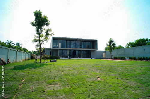Exterior of house in modern style with grass field and garden at the backyard photo