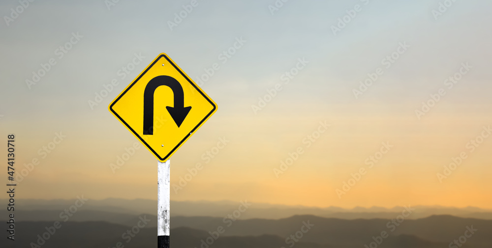 Right turn sign on white pole with clouds and blue sky background.	