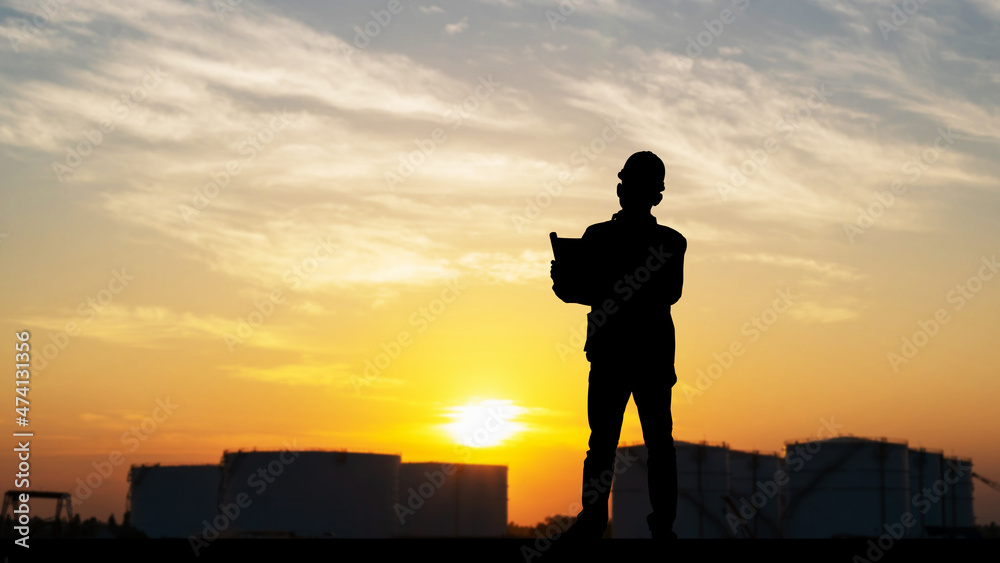 Silhouette of Engineer with clipping path under inspection and checking oil storage tank, Engineer man in waistcoats and hardhats and with documents in oil storage plant Silhouette of Engineer with clipping path under inspection and checking oil storage tank, Engineer man in waistcoats and hardhats and with documents in oil storage plant