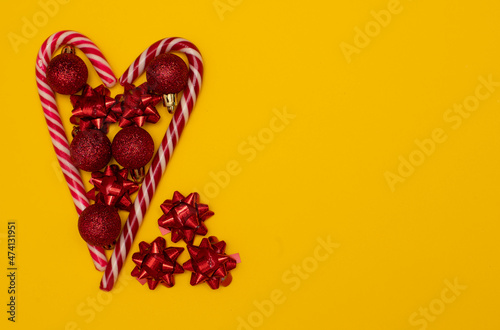 Christmass flatlay heart lined with Christmas lollipops and decorated with Christmas tree toys 