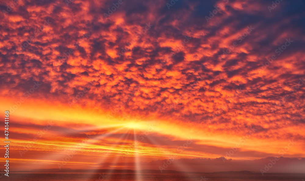 Spectacular Sunrise Sky in Yellow, Orange and Red Colors with Sun and Sunrays