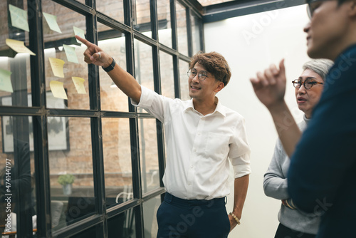 Businessman finger point at note with business team in office