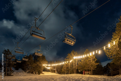 People with snowshoes in a , snow,ski resort at night