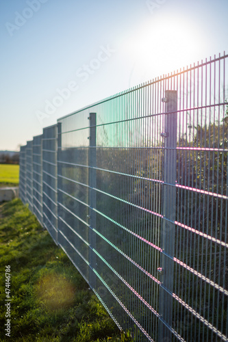 Metal fence shines in the sunlight