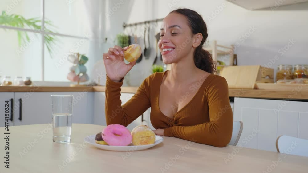 Latino attractive woman enjoy eat unhealthy foods in kitchen at home. Latino attractive woman enjoy eat unhealthy foods in kitchen at home.