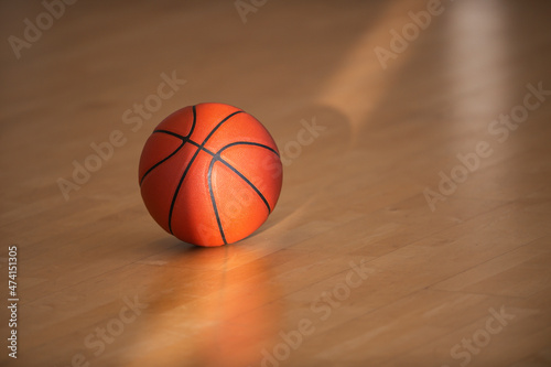 Basketball on hardwood court floor with natural lighting. Workout online concept, Horizontal sport theme poster, greeting cards, headers, website and app