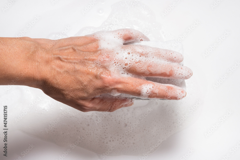 Hand with foam holding sponge, on white background